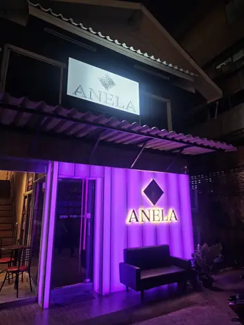 ANELA: shopfront with the lit sign