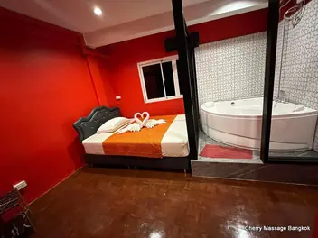 Cherry Massage Bangkok: red room with a bed and jacuzzi behind glass
