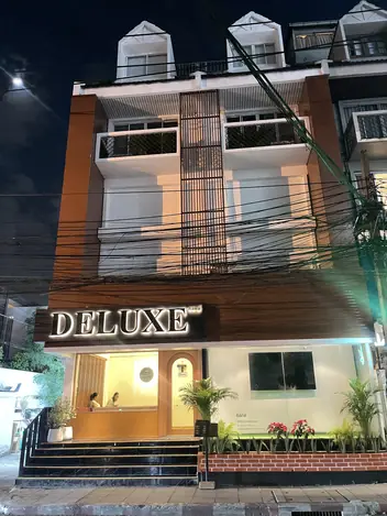 Deluxe Massage: building with the lit sign at night