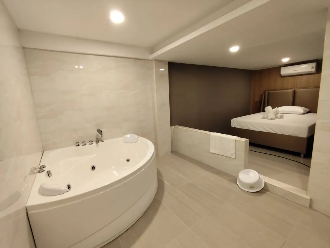 Hakumi Nuru Massage: room with a corner jacuzzi and bed