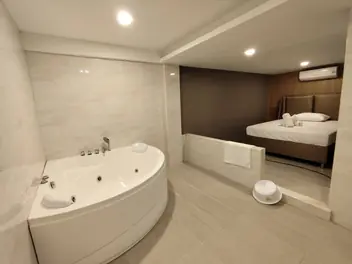 Hakumi Nuru Massage: room with a corner jacuzzi and bed