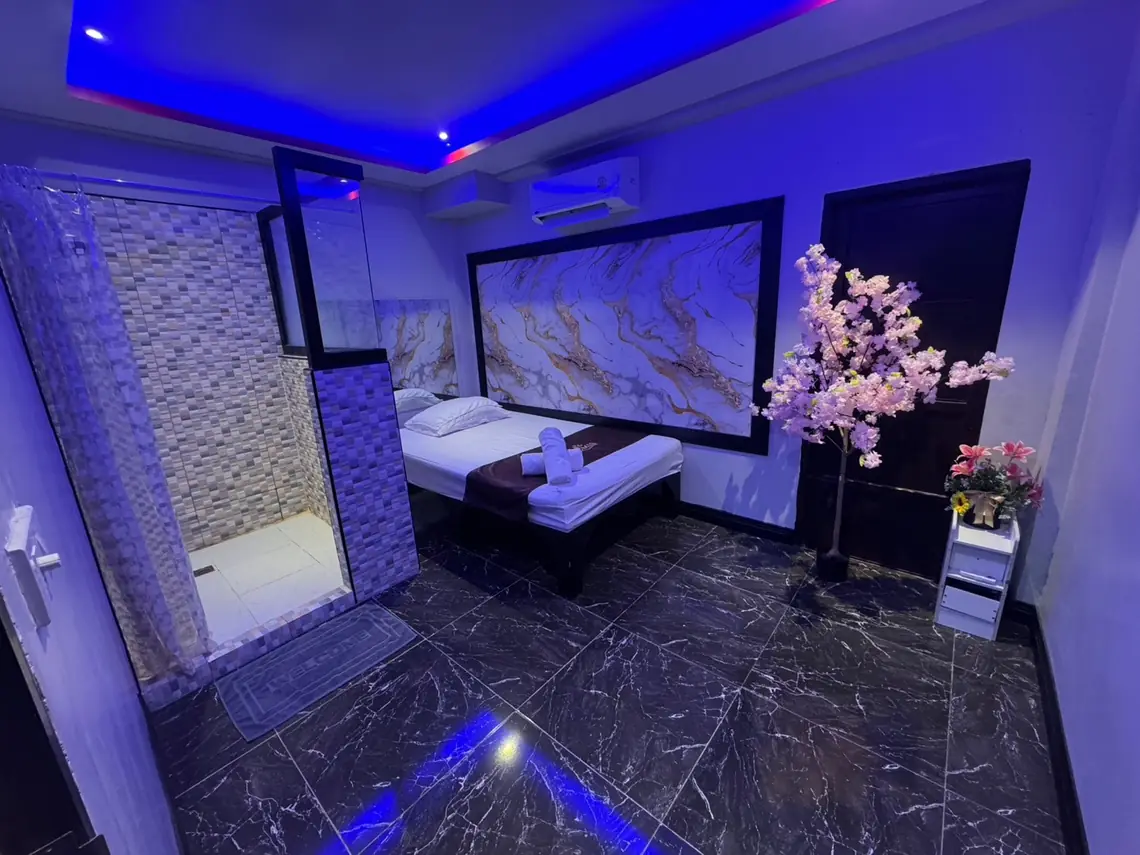 Lumis Bangkok: blue-lit room with massage bed and marble wall