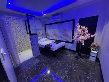 Lumis Bangkok: blue-lit room with massage bed and marble wall