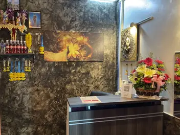 Sky Massage: reception counter with flowers and a marble-effect wall
